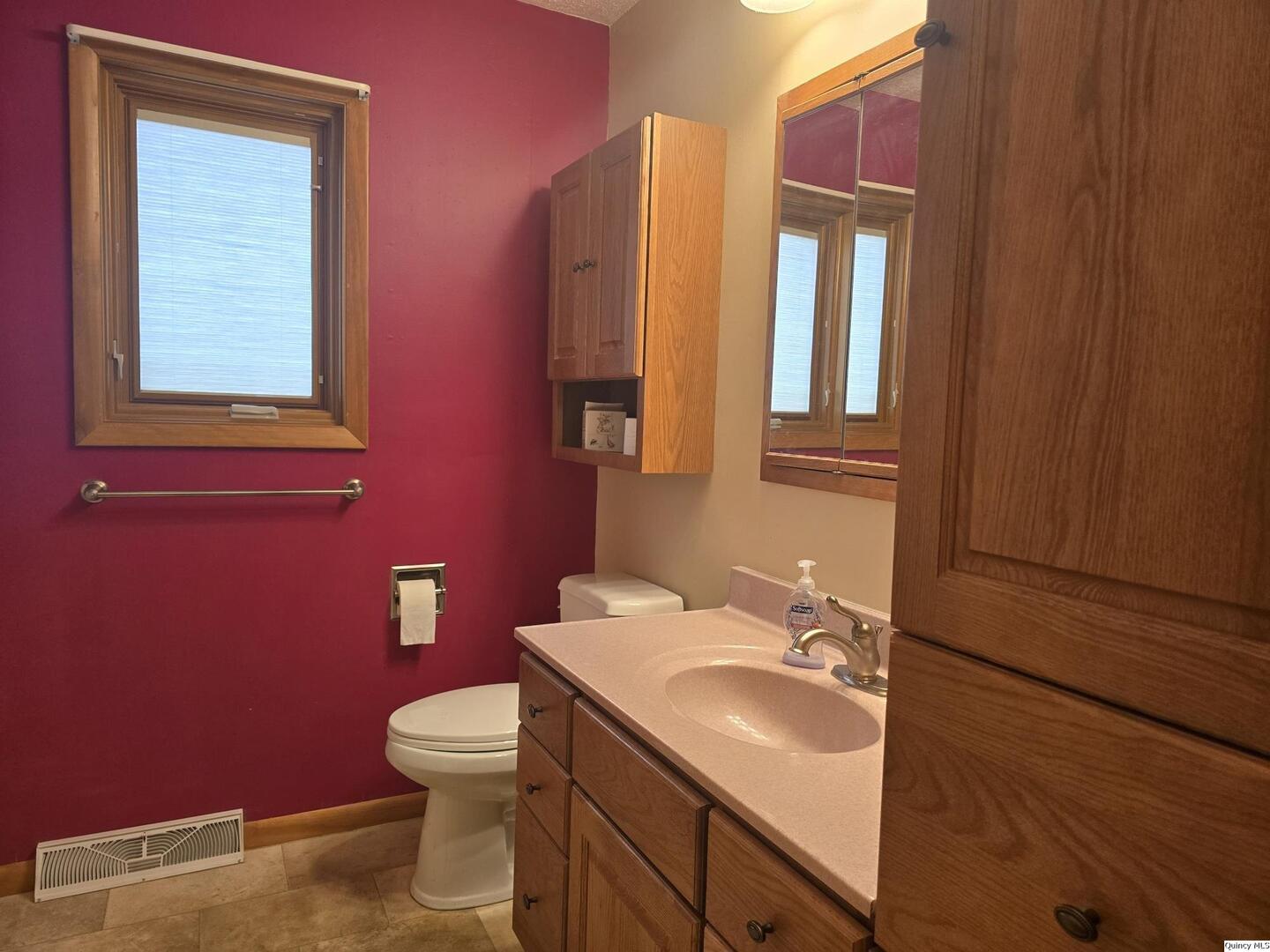 239 Rogers Road Carthage, IL 62321 - Photo 11 of 23 a bathroom with a toilet sink vanity and mirror