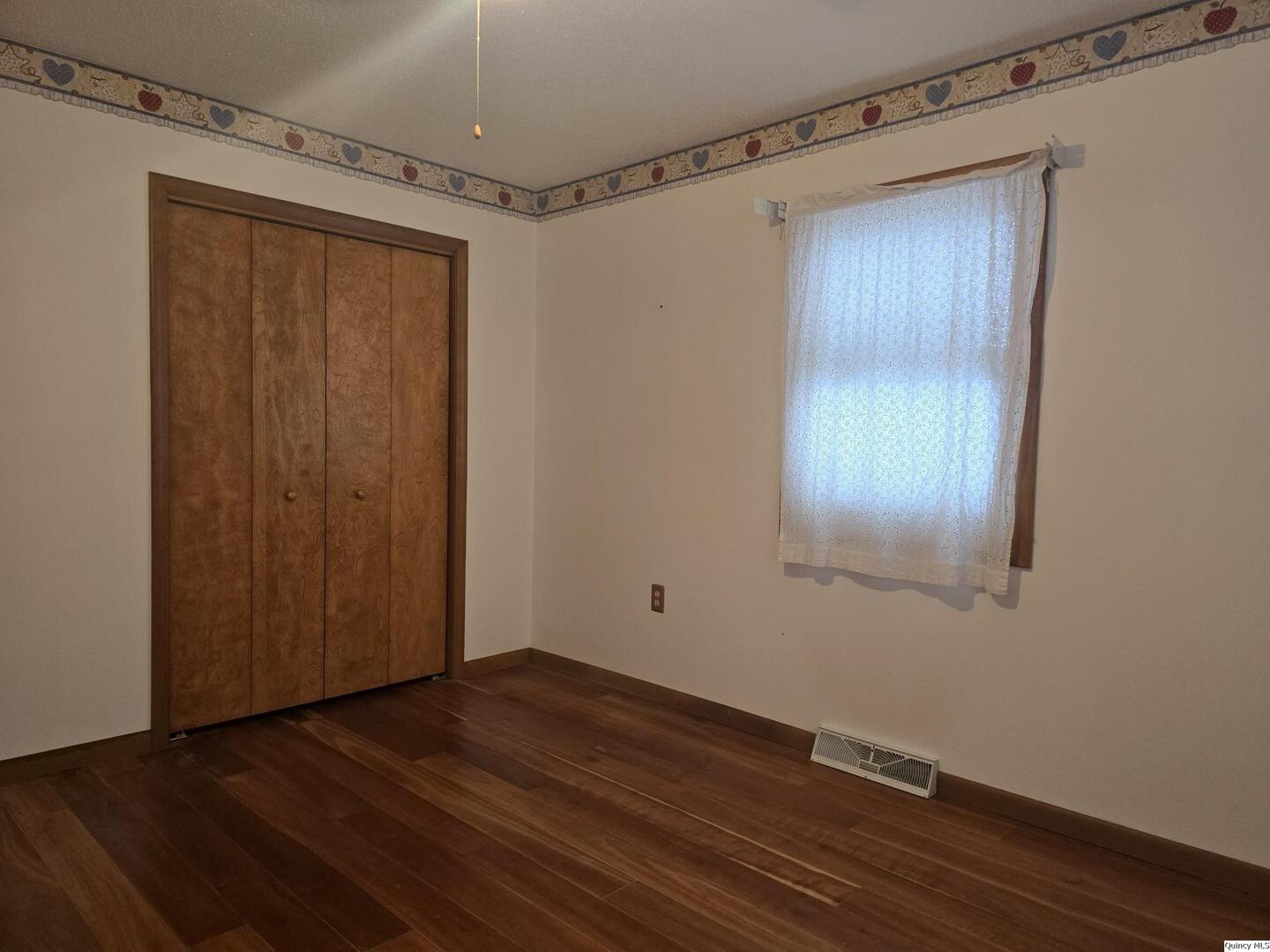 239 Rogers Road Carthage, IL 62321 - Photo 14 of 23 a view of an empty room with wooden floor and a window