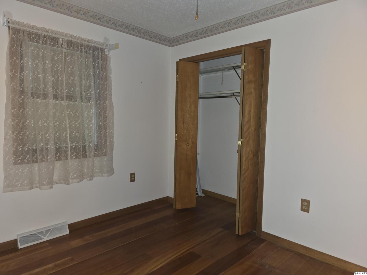 239 Rogers Road Carthage, IL 62321 - Photo 16 of 23 a view of an empty room with wooden floor and a window
