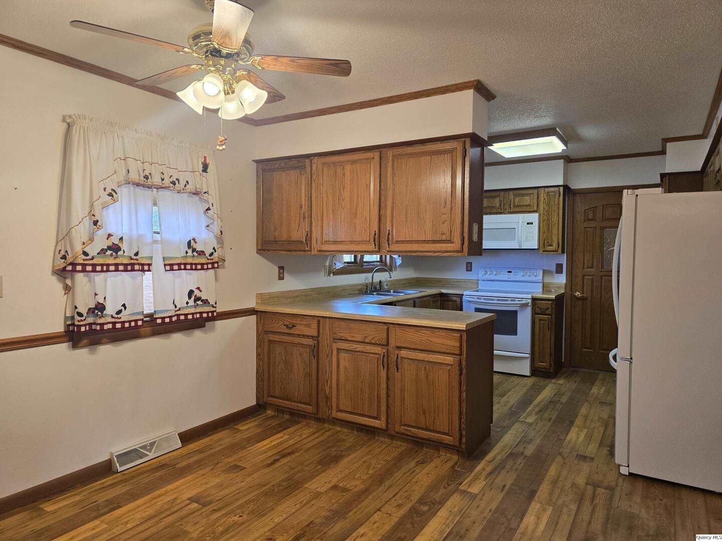 239 Rogers Road Carthage, IL 62321 - Photo 5 of 23 a kitchen with stainless steel appliances granite countertop a refrigerator a sink dishwasher a stove and white countertops with wooden floor