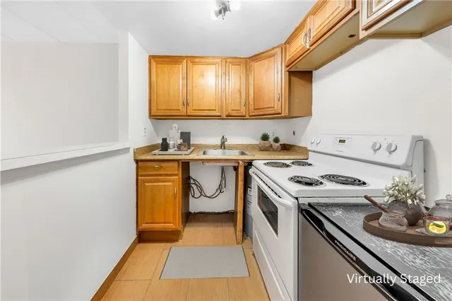 a kitchen with a sink a stove cabinets and a window