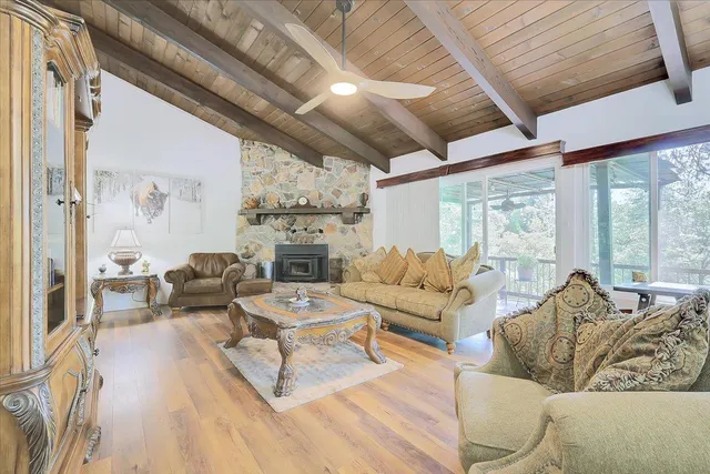 a living room with furniture fireplace and large windows