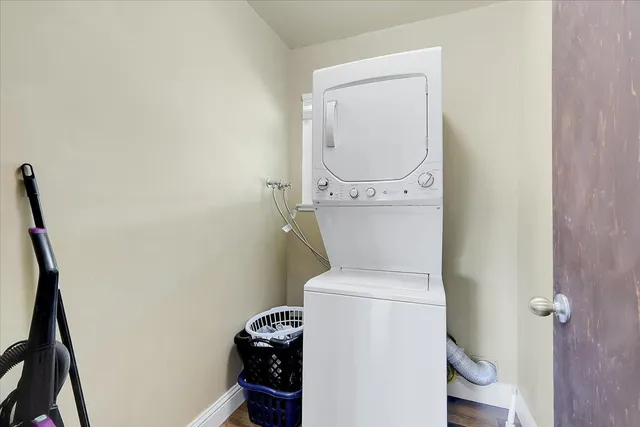 a view of an empty room with wooden floor and closet