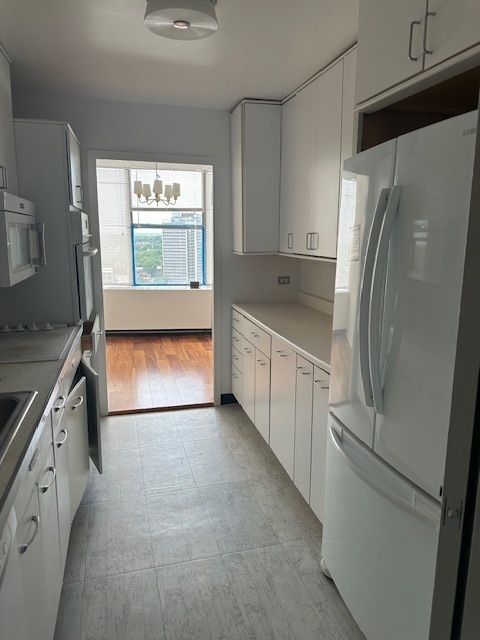 5757 North Sheridan Road, Unit 18J Chicago, IL 60660 - Photo 9 of 19 a kitchen with stainless steel appliances granite countertop a refrigerator a sink and white cabinets