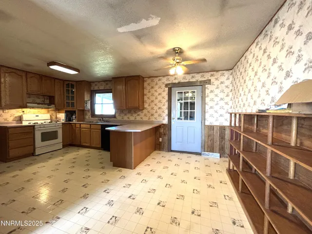 a kitchen with stainless steel appliances a sink a stove a refrigerator cabinets and living room view