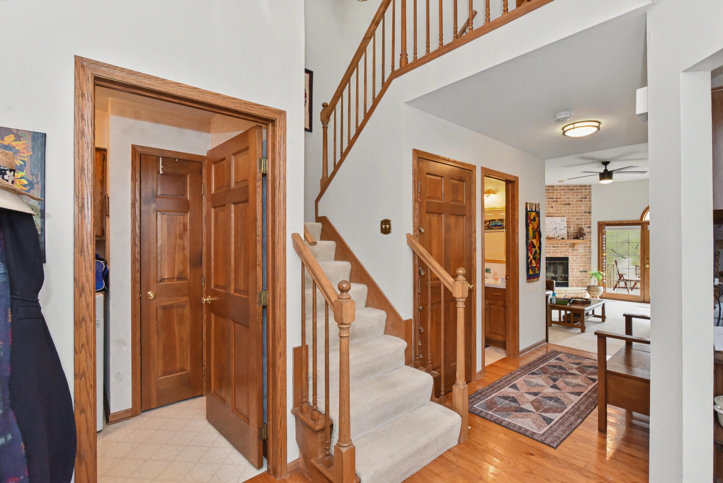 2870 Teal Ridge Court, Unit B Brookfield, WI 53045 - Photo 4 of 42 View from the front entry showing the staircase to the upper level, convenient first-floor laundry, and hallway leading to the great room.