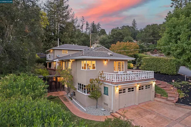 a front view of a house with a garden and trees