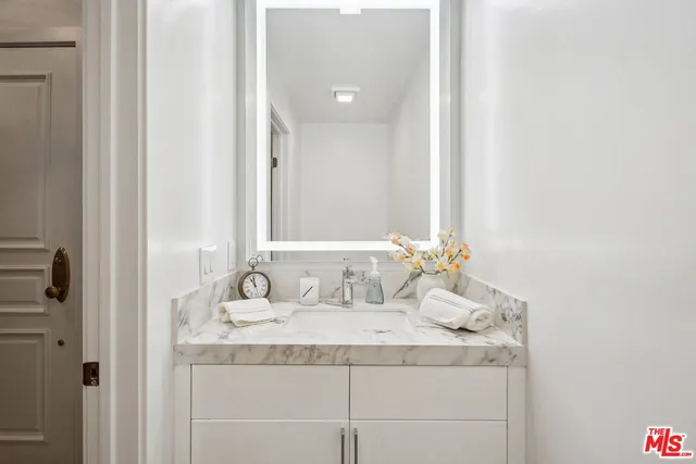 a bathroom with a granite countertop sink and a mirror
