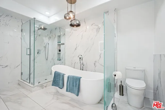 a spacious bathroom with a toilet sink and shower