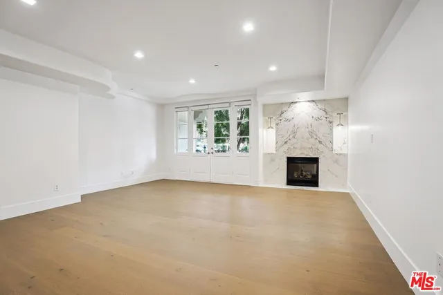 a view of an empty room with a fireplace and a window