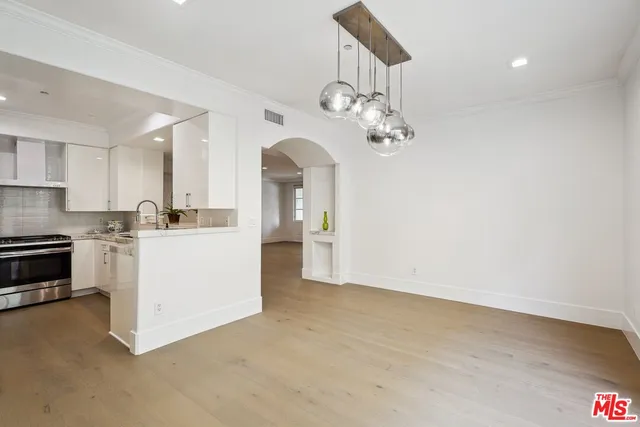 a view of a kitchen with a sink and dishwasher a kitchen island with wooden floor
