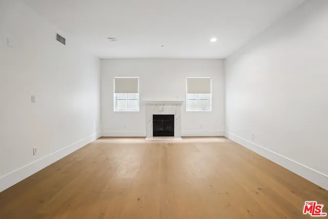 a view of an empty room with a fireplace and a window