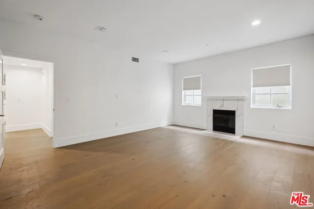 an empty room with fireplace and windows