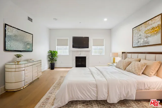 a spacious bedroom with a bed and a flat screen tv