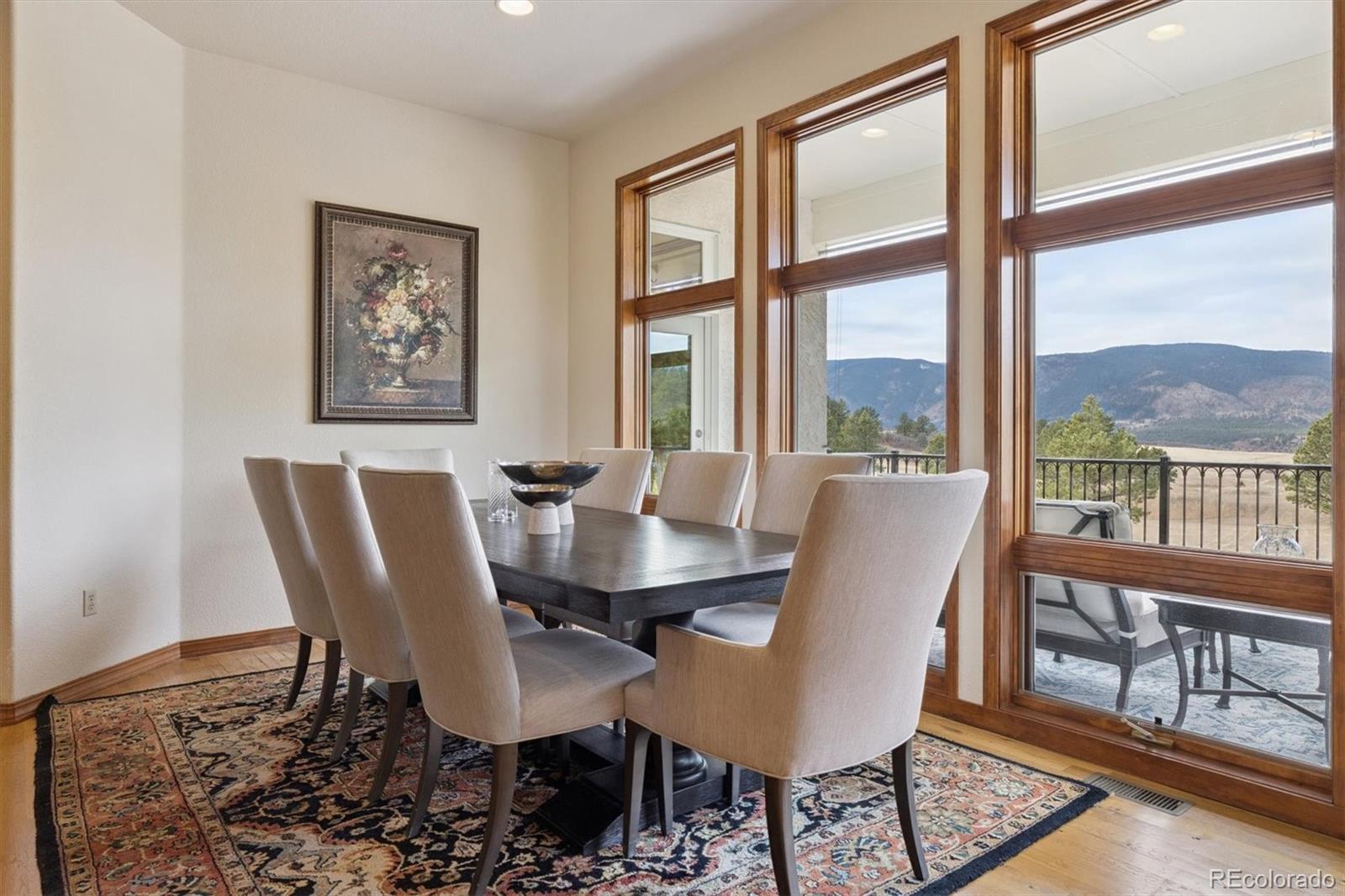 8061 Sugar Loaf Road Larkspur, CO 80118 - Photo 11 of 48 a view of a dining room with furniture large windows and wooden floor
