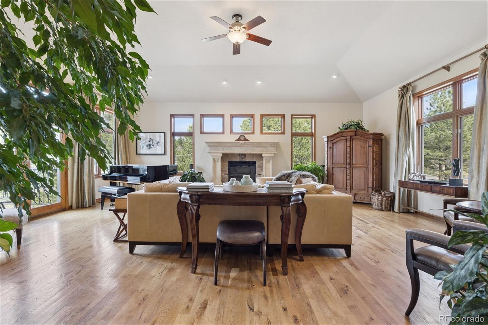 8061 Sugar Loaf Road Larkspur, CO 80118 - Photo 12 of 48 a living room with furniture a fireplace and a large window