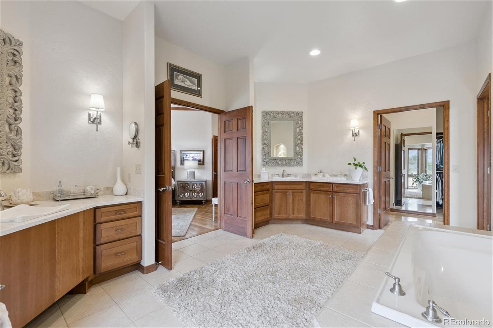 8061 Sugar Loaf Road Larkspur, CO 80118 - Photo 22 of 48 a spacious bathroom with a tub sink and mirror