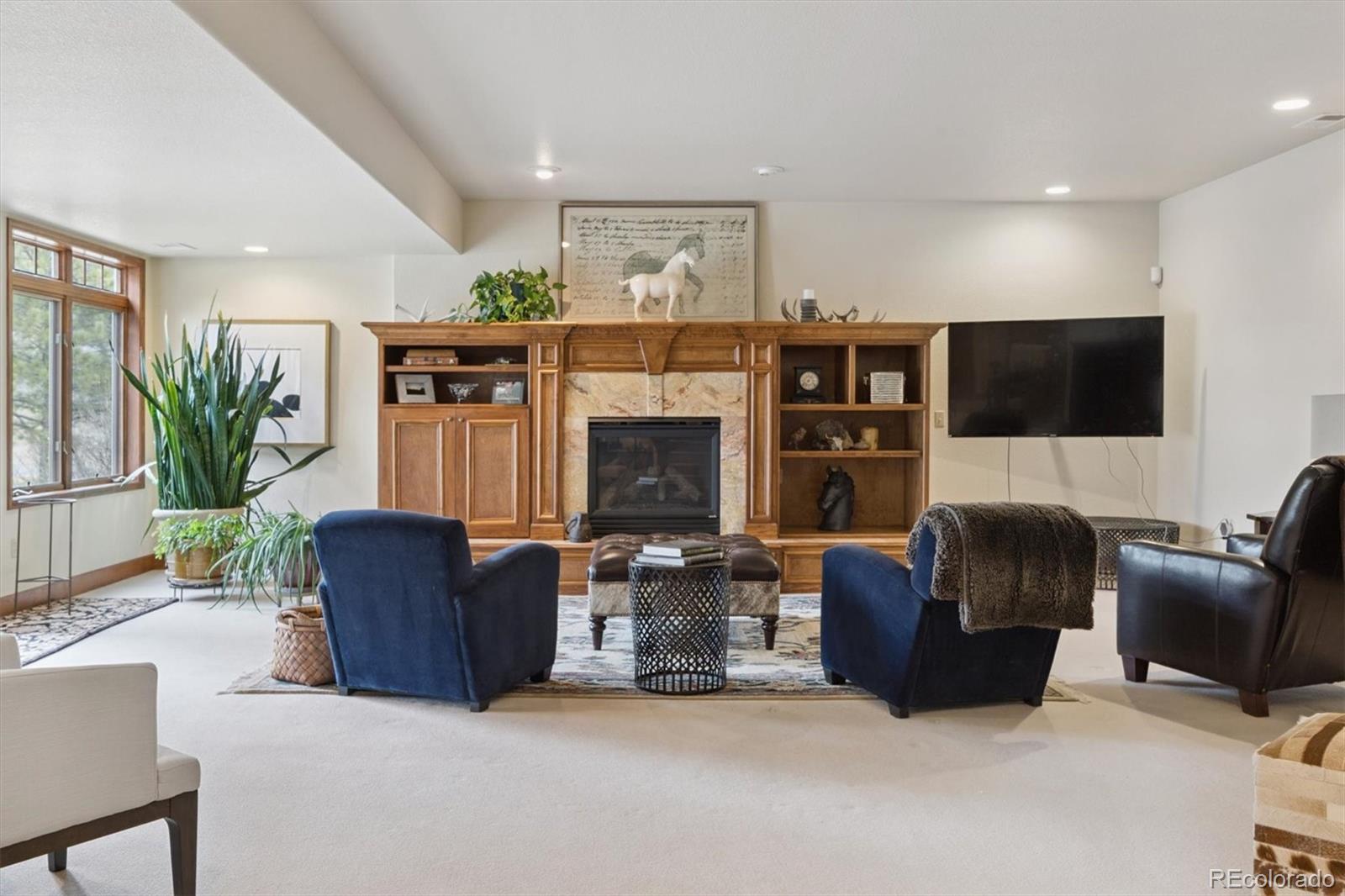 8061 Sugar Loaf Road Larkspur, CO 80118 - Photo 32 of 48 a living room with furniture and a fireplace