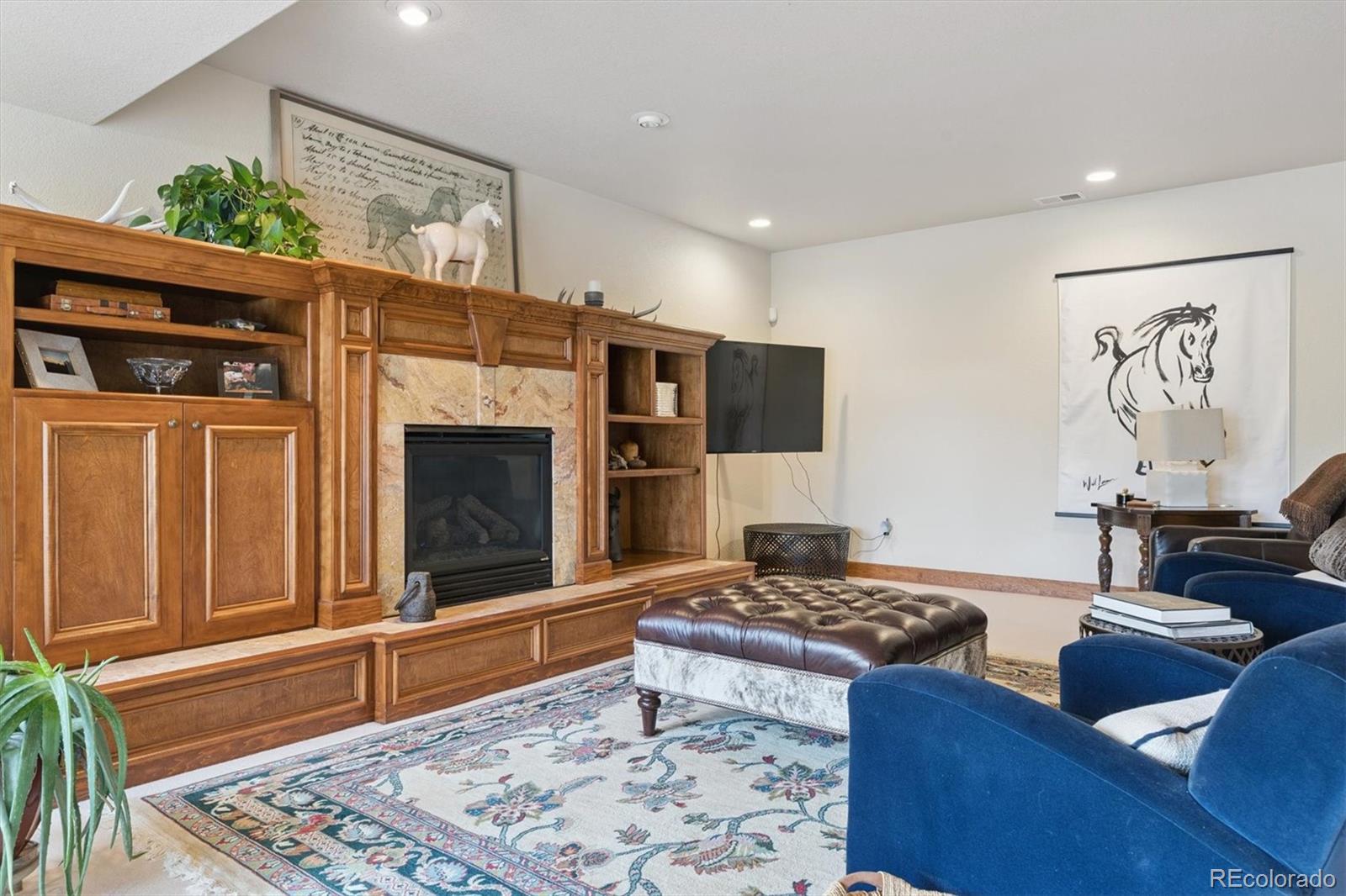 8061 Sugar Loaf Road Larkspur, CO 80118 - Photo 35 of 48 a living room with furniture flat screen tv and a fireplace