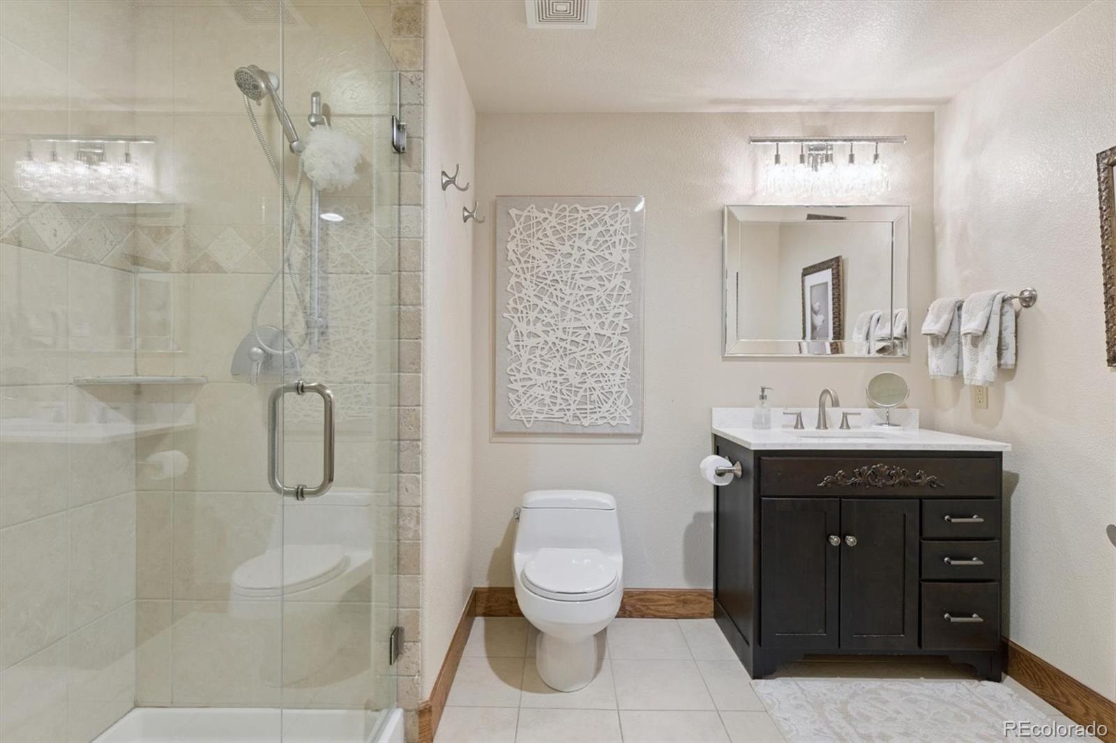 8061 Sugar Loaf Road Larkspur, CO 80118 - Photo 38 of 48 a bathroom with a granite countertop sink toilet and shower