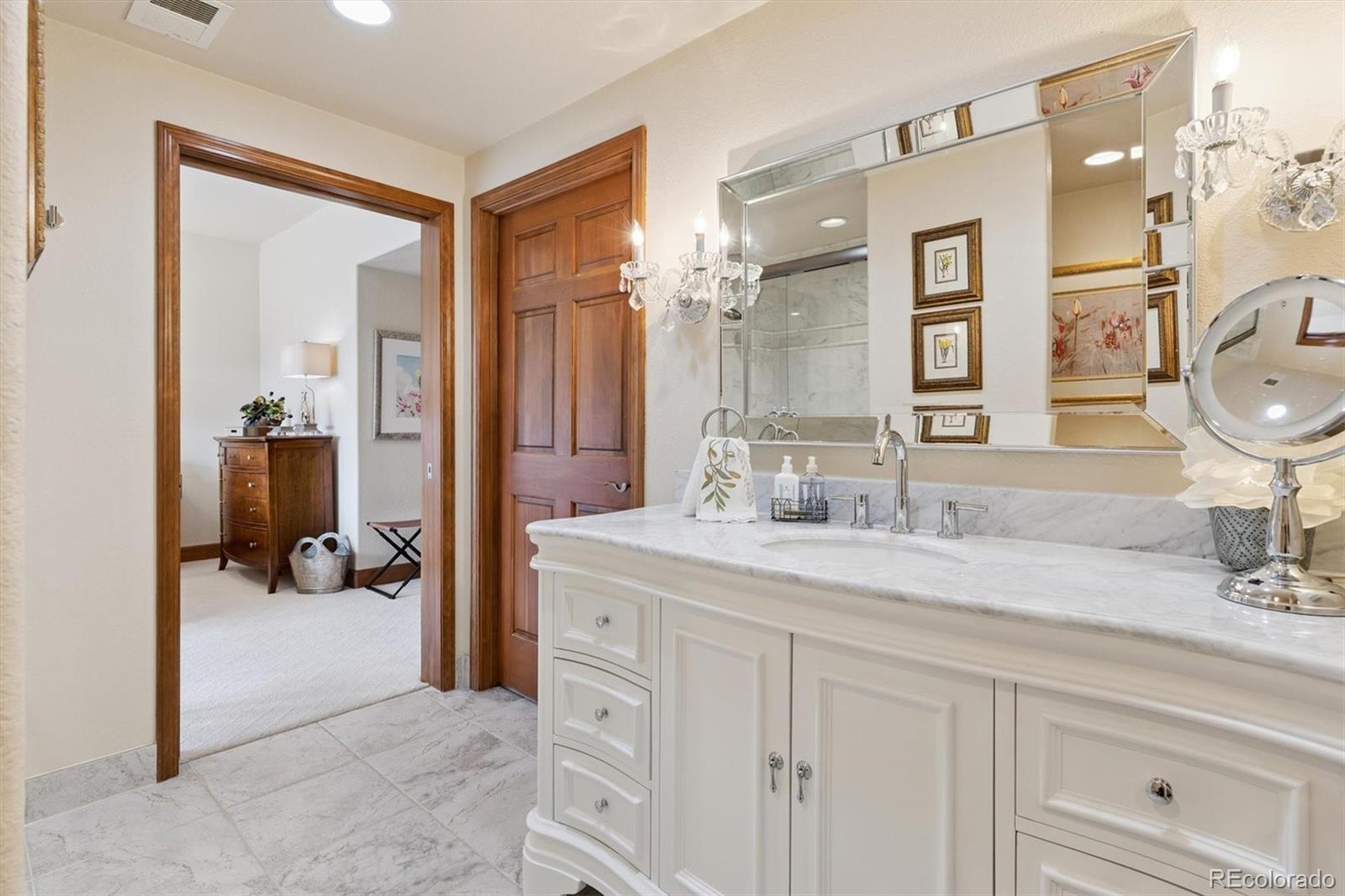 8061 Sugar Loaf Road Larkspur, CO 80118 - Photo 45 of 48 a en suite bathroom with double sink and a mirror