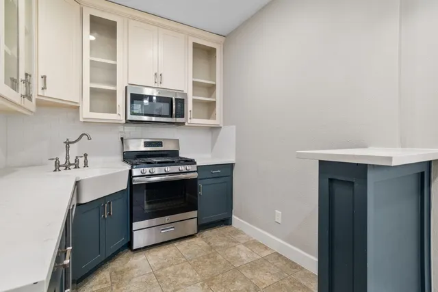 a kitchen with stainless steel appliances granite countertop white cabinets a stove top oven a sink and dishwasher