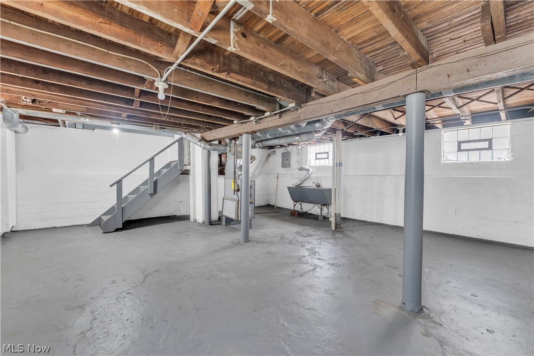 12808 Havana Road Cleveland, OH 44125 - Photo 17 of 19 Open basement area featuring exposed ceiling joists, painted concrete flooring, and a utility sink