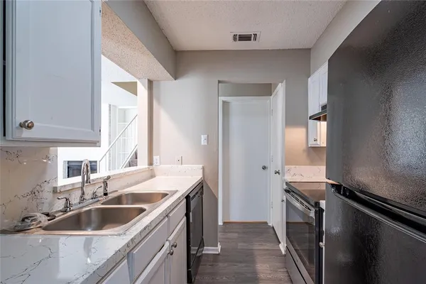 a kitchen with a sink and a refrigerator
