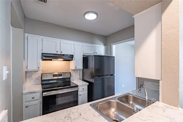 a kitchen with a sink stove and refrigerator