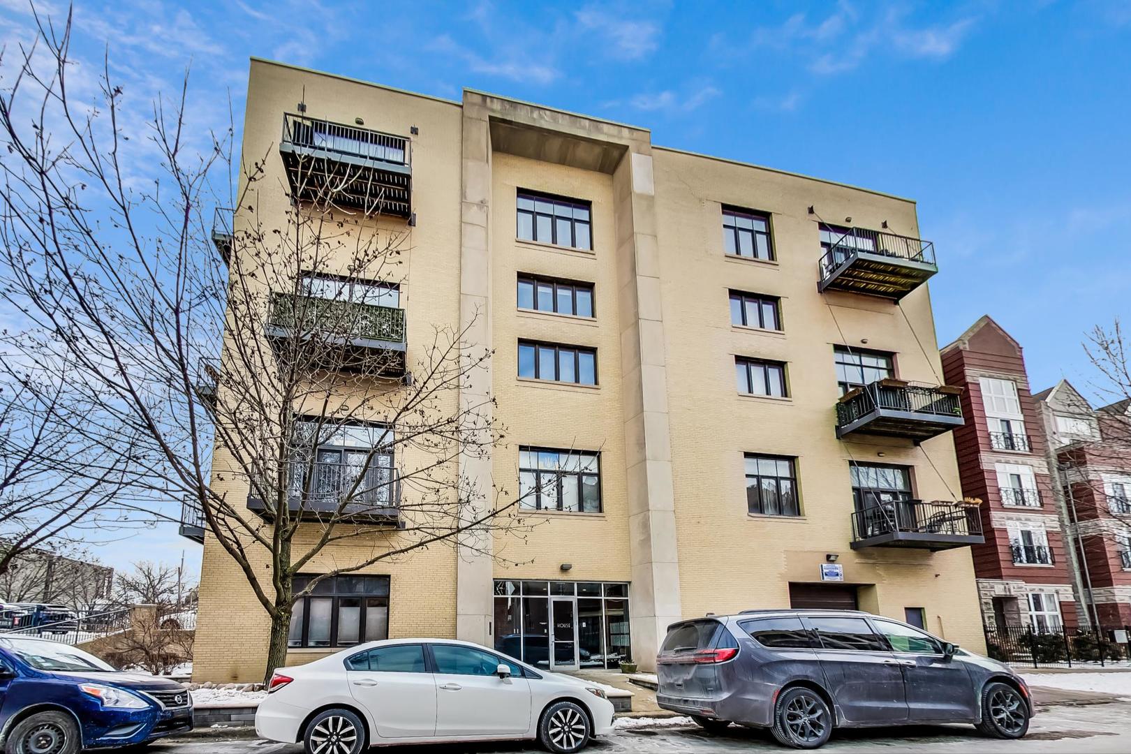 2101 West Rice Street, Unit 103 Chicago, IL 60622 - Photo 1 of 44 a front view of a building with lot of cars and trees