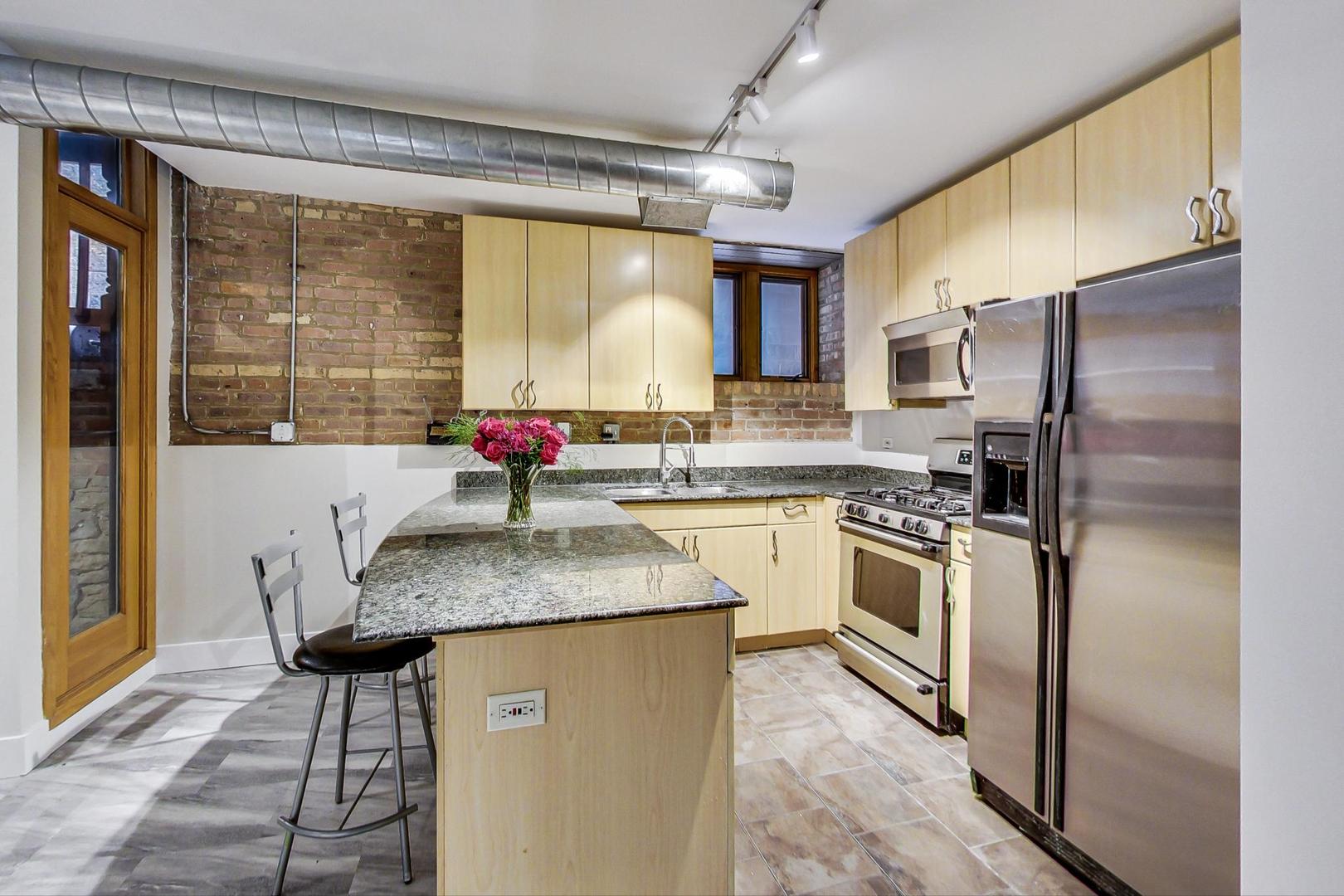 2101 West Rice Street, Unit 103 Chicago, IL 60622 - Photo 12 of 44 a kitchen with stainless steel appliances granite countertop a sink stove and refrigerator