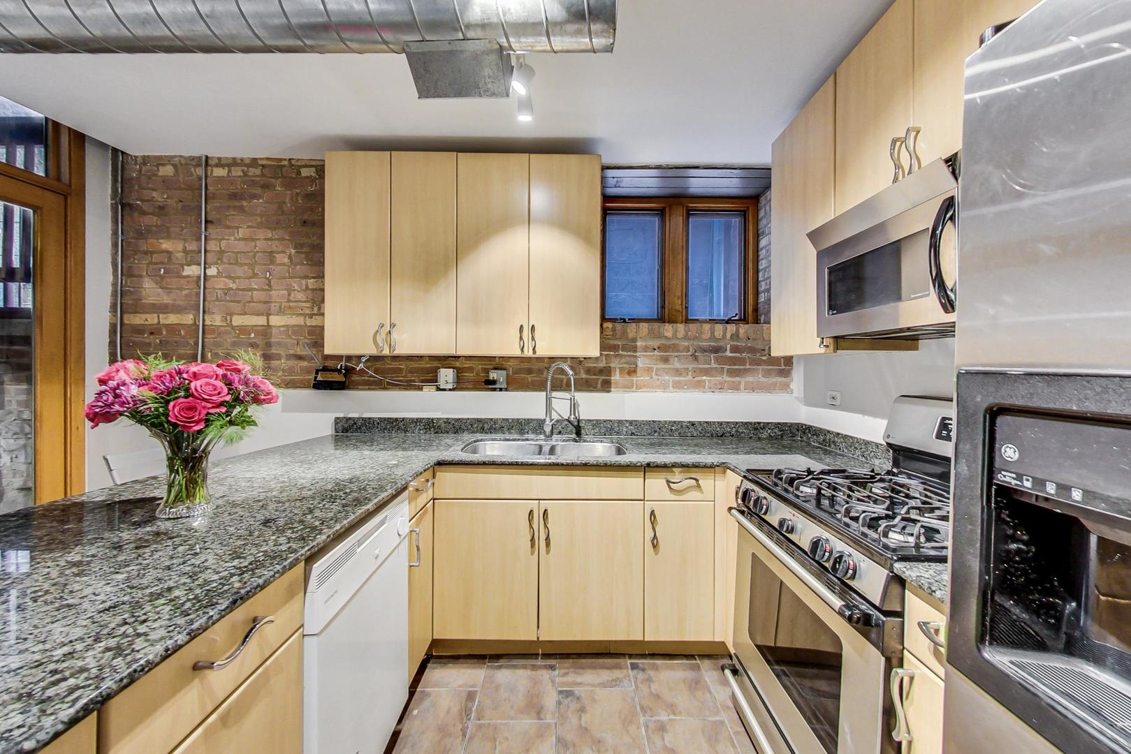 2101 West Rice Street, Unit 103 Chicago, IL 60622 - Photo 13 of 44 a kitchen with granite countertop a sink stove and cabinets