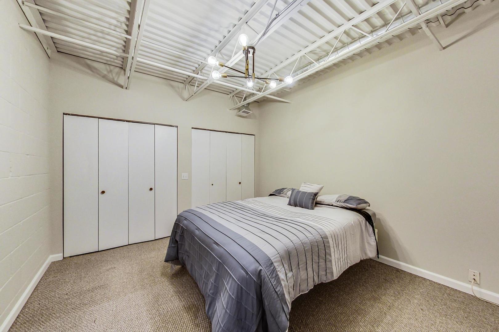 2101 West Rice Street, Unit 103 Chicago, IL 60622 - Photo 15 of 44 a bedroom with a bed and a ceiling fan