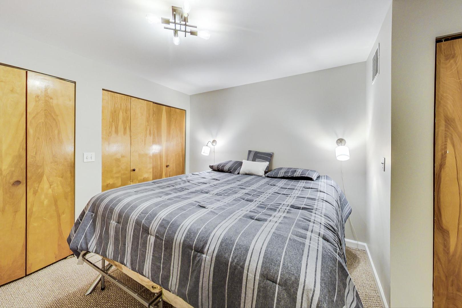 2101 West Rice Street, Unit 103 Chicago, IL 60622 - Photo 26 of 44 a bedroom with a bed and a chandelier