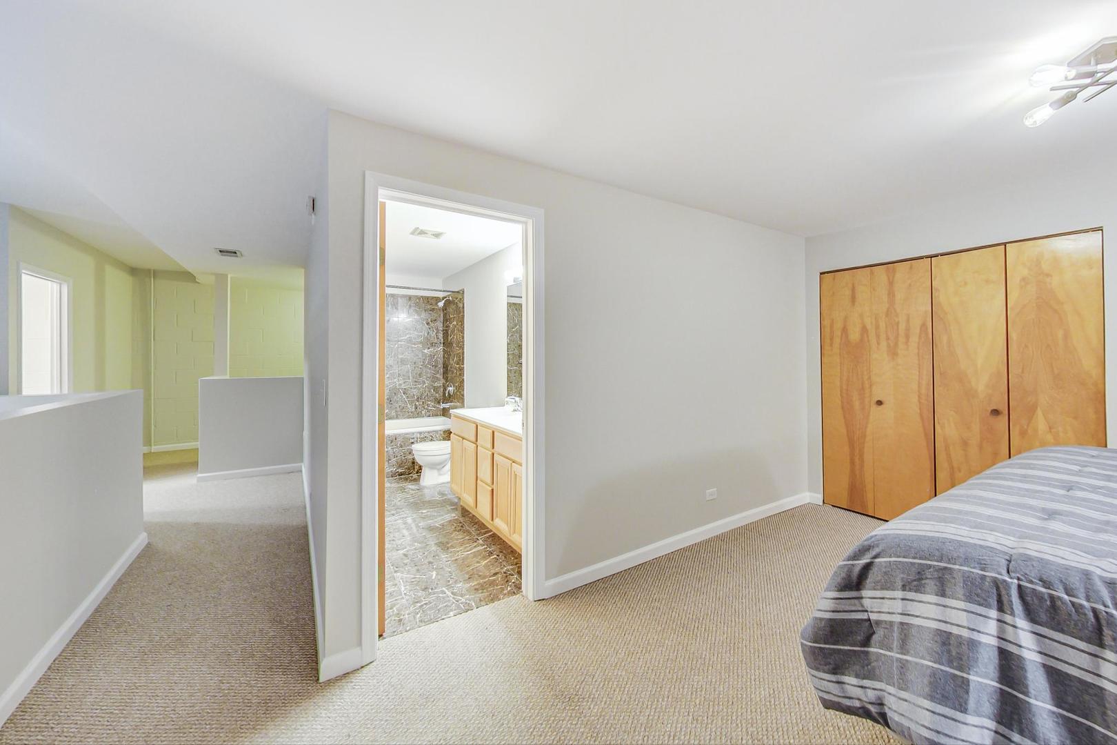 2101 West Rice Street, Unit 103 Chicago, IL 60622 - Photo 27 of 44 a bedroom with a bed and a view of bathroom