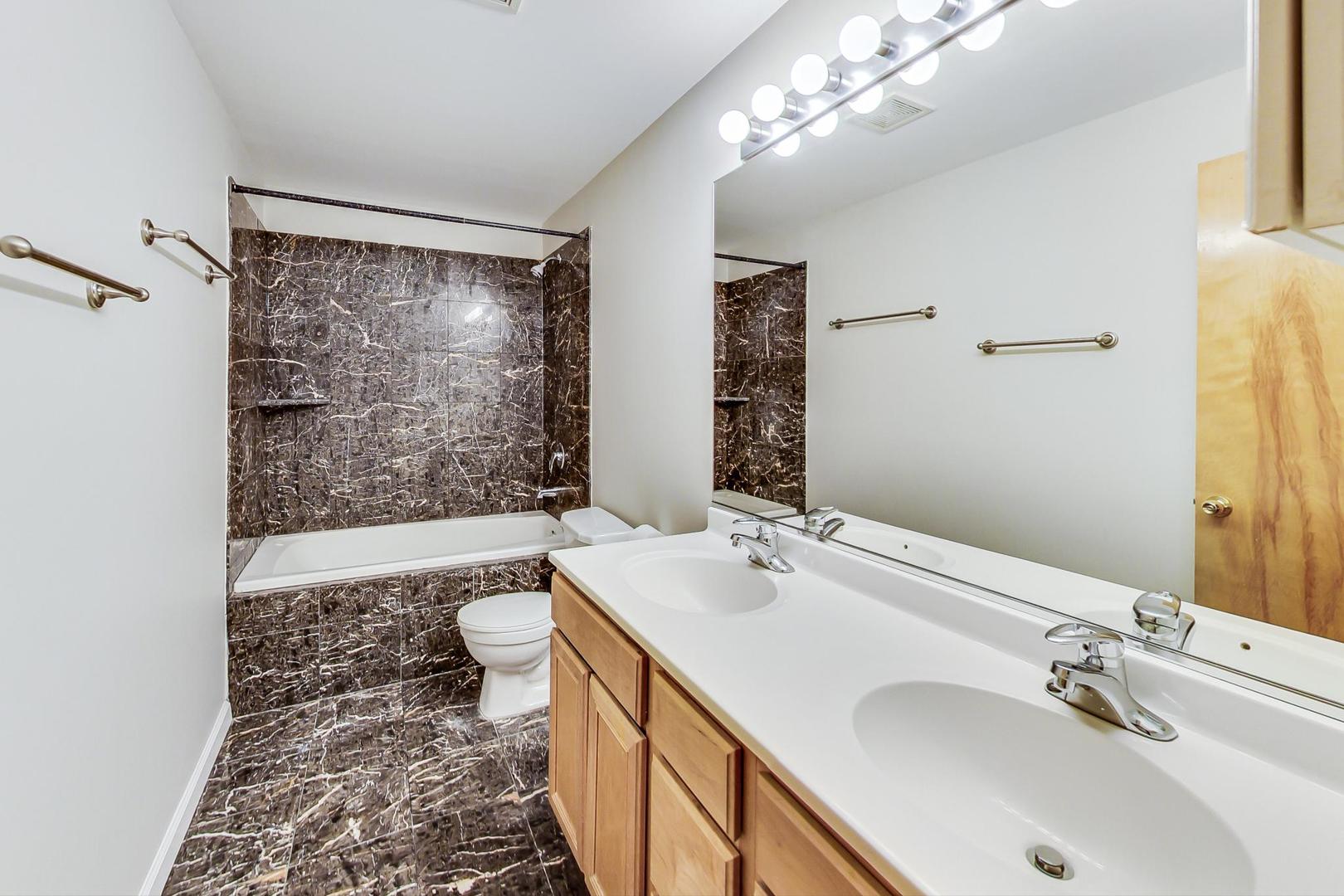 2101 West Rice Street, Unit 103 Chicago, IL 60622 - Photo 29 of 44 a bathroom with a double vanity sink toilet and shower