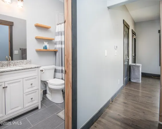 a bathroom with a granite countertop toilet sink and mirror