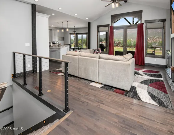 a living room with furniture flat screen tv and a large window