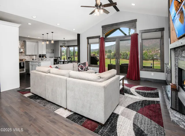 a living room with furniture a flat screen tv and a floor to ceiling window