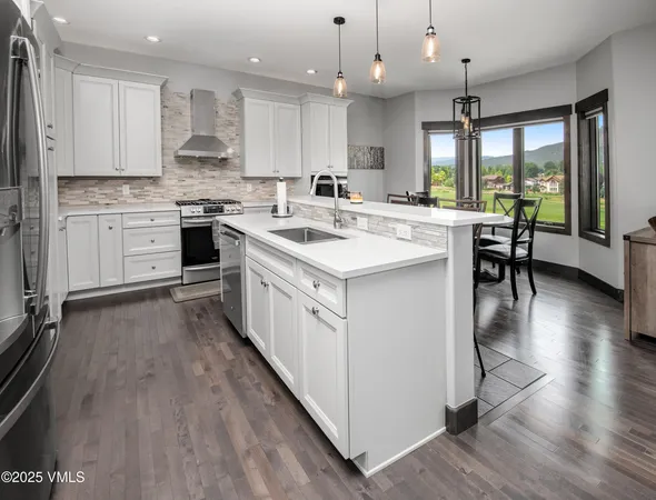 a kitchen with stainless steel appliances a refrigerator and a stove top oven