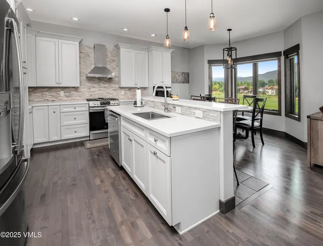 a kitchen with stainless steel appliances a refrigerator and a stove top oven