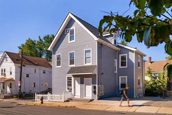a front view of a house with a tree