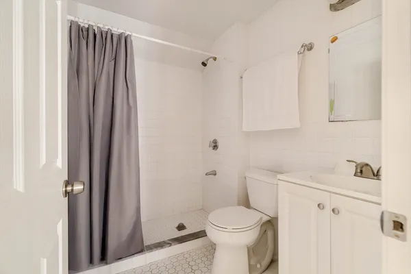 a bathroom with a sink a toilet and shower