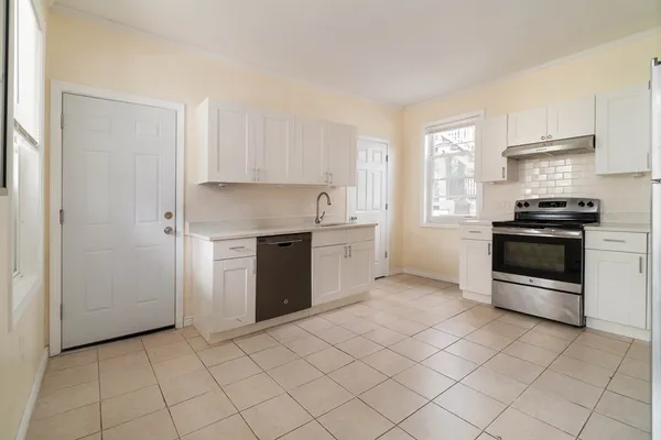 a kitchen with a stove top oven and cabinets