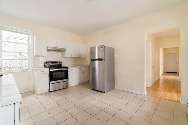 a kitchen with a refrigerator and a stove top oven
