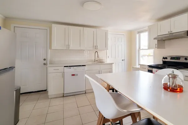 a kitchen with a sink a stove cabinets and a refrigerator