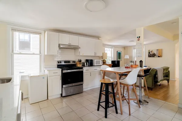 a kitchen with a table chairs sink and cabinets