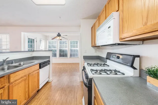 a kitchen with stainless steel appliances a stove a sink dishwasher and cabinets with wooden floor