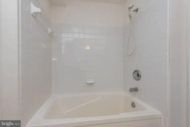 a white bath tub sitting next to a white sink and vanity