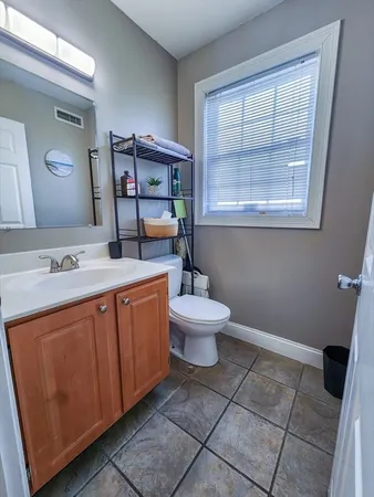 a spacious bathroom with a toilet sink and mirror